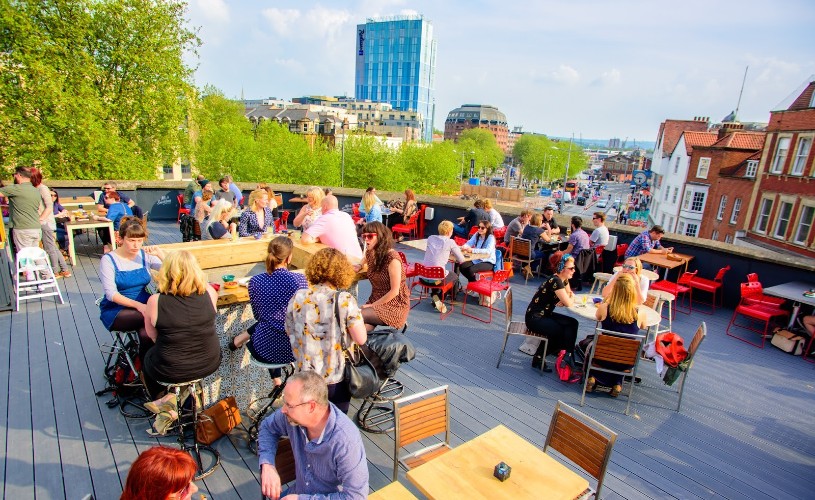 People sat around tables on the roof terrace at Bambalan